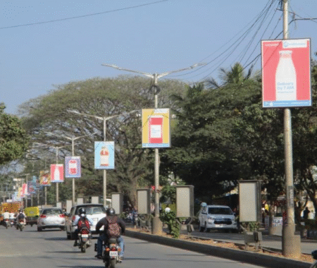 Pole kiosk advertising in Mumbai by ACME Advertising Co., showcasing vibrant street-level branding on high-traffic roads.