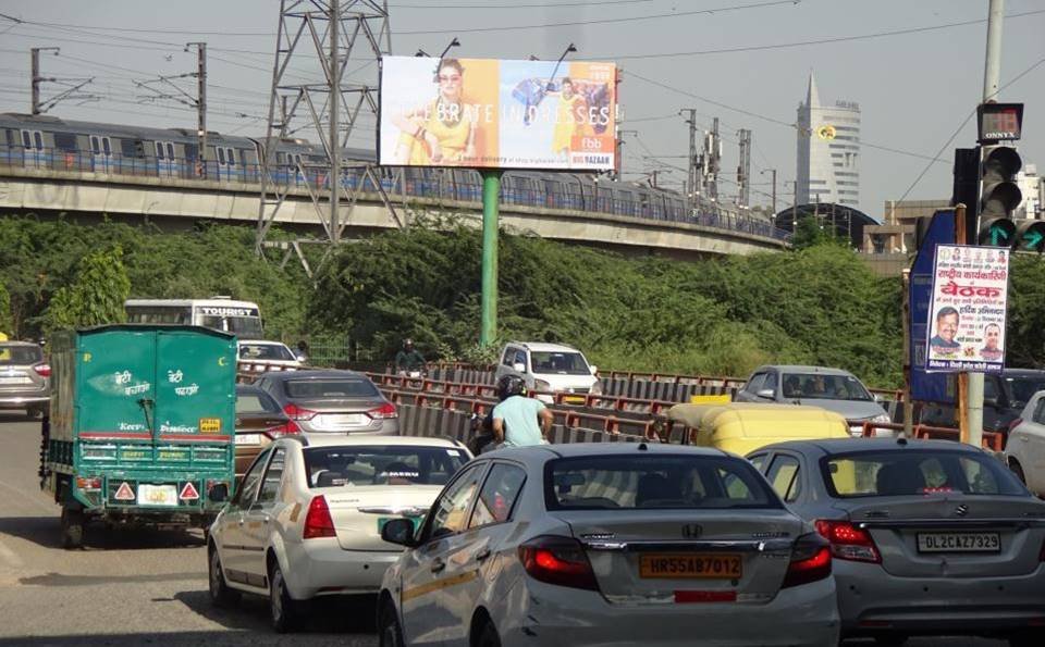 Large outdoor Unipole by Acme Advertiser displayed on a busy roadside, showcasing high-impact hoarding advertising for brand visibility in urban India. Digital Billboard Advertising Companies in Delhi 