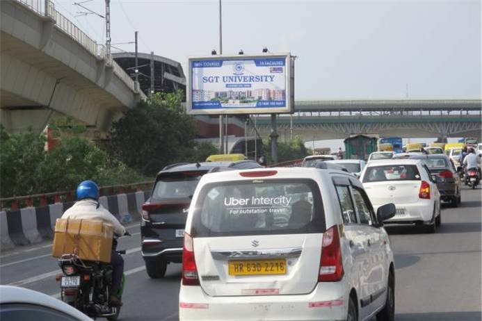 Large outdoor Unipole by Acme Advertiser displayed on a busy roadside, showcasing high-impact hoarding advertising for brand visibility in urban India.