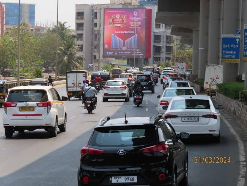 Street view of branded displays by leading Pole Kiosk Advertising Companies in Mumbai on a busy urban road with consistent foot and vehicle traffic