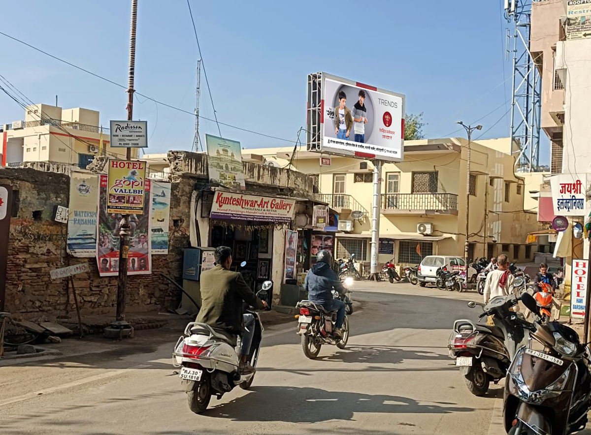 Large roadside billboard in Rajasthan displaying a vibrant brand advertisement, placed in a high-traffic urban area, showcasing the work of leading billboard advertising companies in Rajasthan. Large roadside billboard in Rajasthan displaying a vibrant brand advertisement, placed in a high-traffic urban area, showcasing the work of leading billboard advertising companies in Rajasthan.