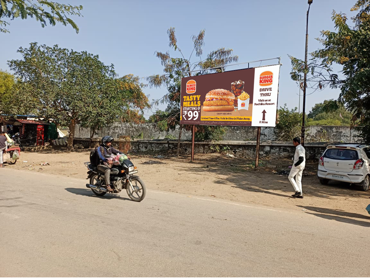 Large roadside billboard in Rajasthan displaying a vibrant brand advertisement, placed in a high-traffic urban area, showcasing the work of leading billboard advertising companies in Rajasthan. Large roadside billboard in Rajasthan displaying a vibrant brand advertisement, placed in a high-traffic urban area, showcasing the work of leading billboard advertising companies in Rajasthan.