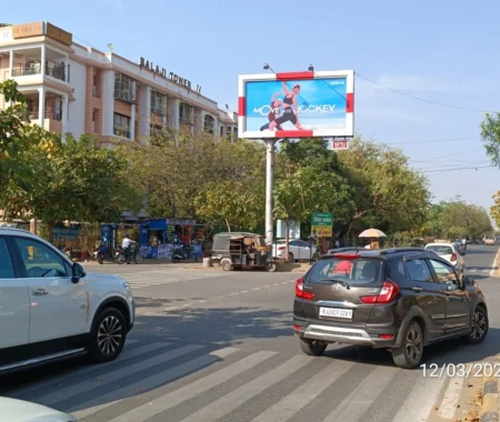Jockey billboard ad near Balaji Tower IV on a sunny street in India, with cars and people around.