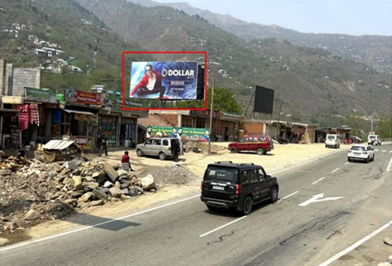Dollar Bigboss Unipole by ACME Advertising Co. on Jammu & Kashmir highway with mountain views and roadside traffic.