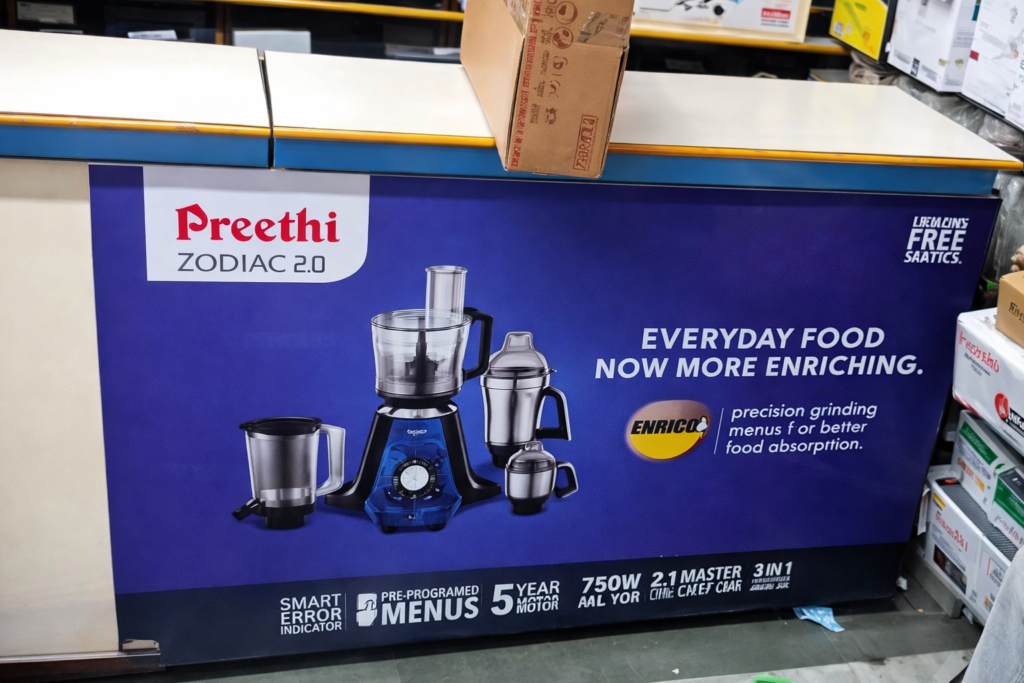 Retail counter branding panel showcasing kitchen appliances and product features inside a store