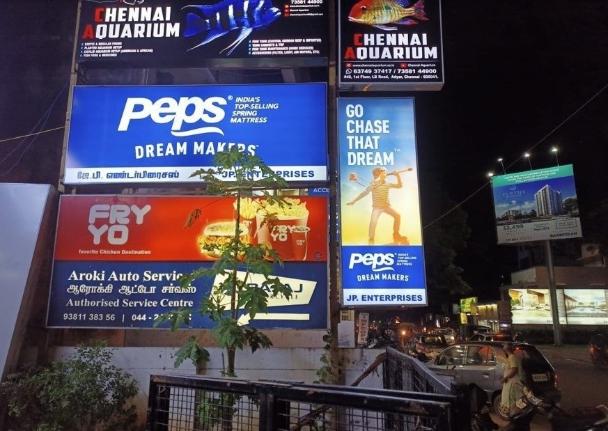 Glow Sign Board Advertising featuring multiple illuminated retail signboards enhancing roadside visibility at night