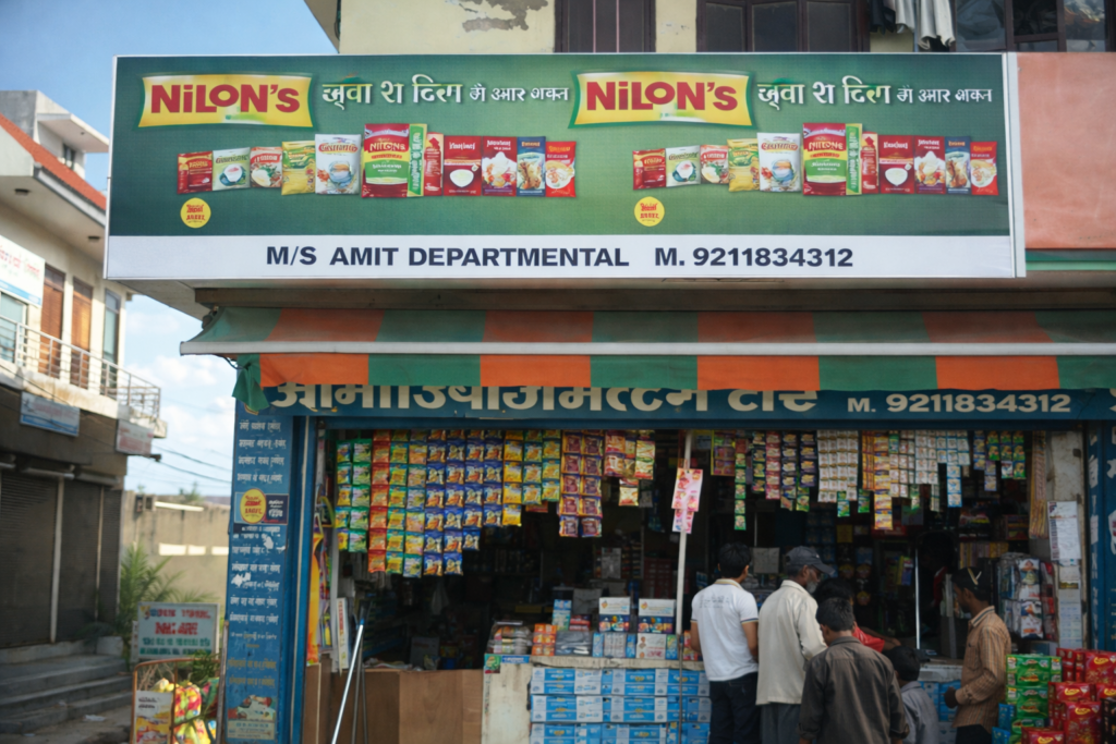 Dealer Board Advertisement for FMCG departmental store highlighting product availability and brand promotions