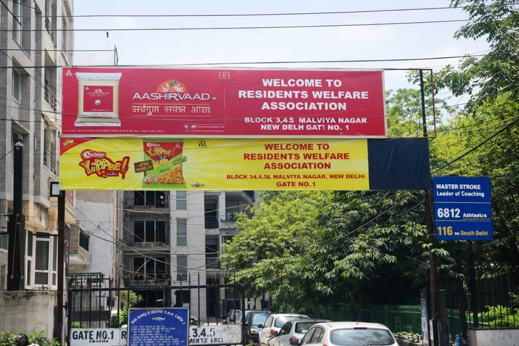 Residents welfare association entrance gate with overhead advertising board in Indian housing society