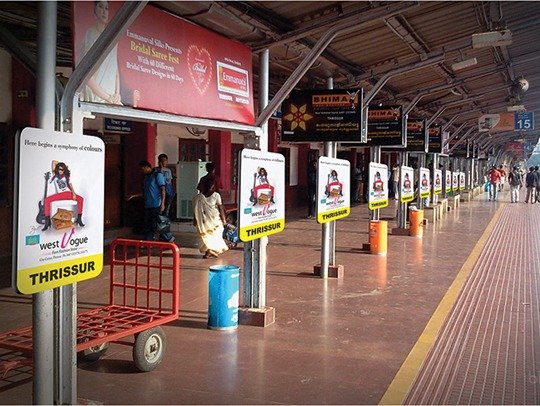 Railway station branding displays placed along an Indian railway platform, showcasing outdoor advertising panels targeting daily commuters and travelers